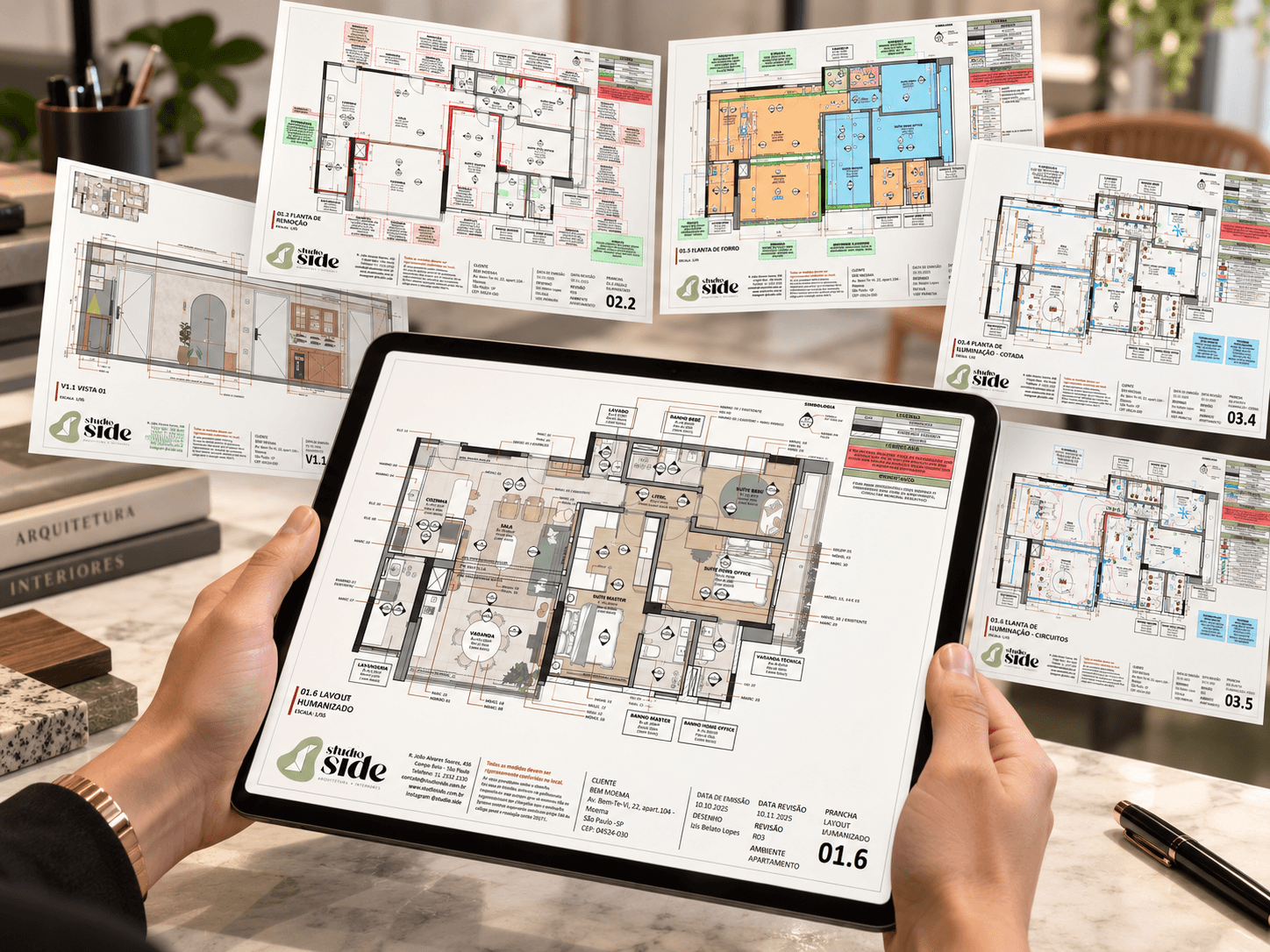 Mãos segurando um tablet com a planta de layout humanizado da Studio Side, cercado de pranchas técnicas do projeto executivo, como plantas de remoção, forro e iluminação